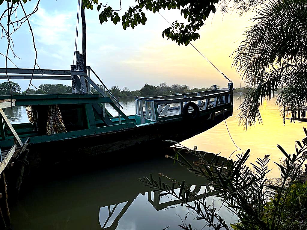 Boat beside the water at sunrise near Lamin Lodge